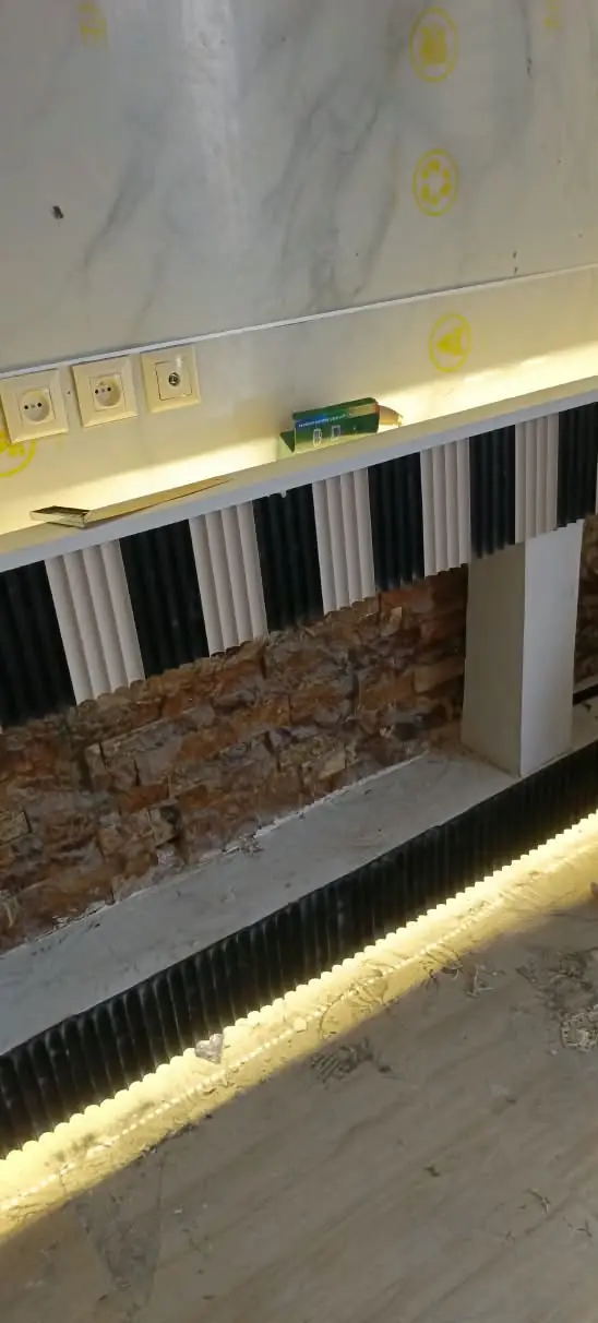 Finitions intérieures — Panneaux effet marbre, lames cannelées, parement pierre et LED.